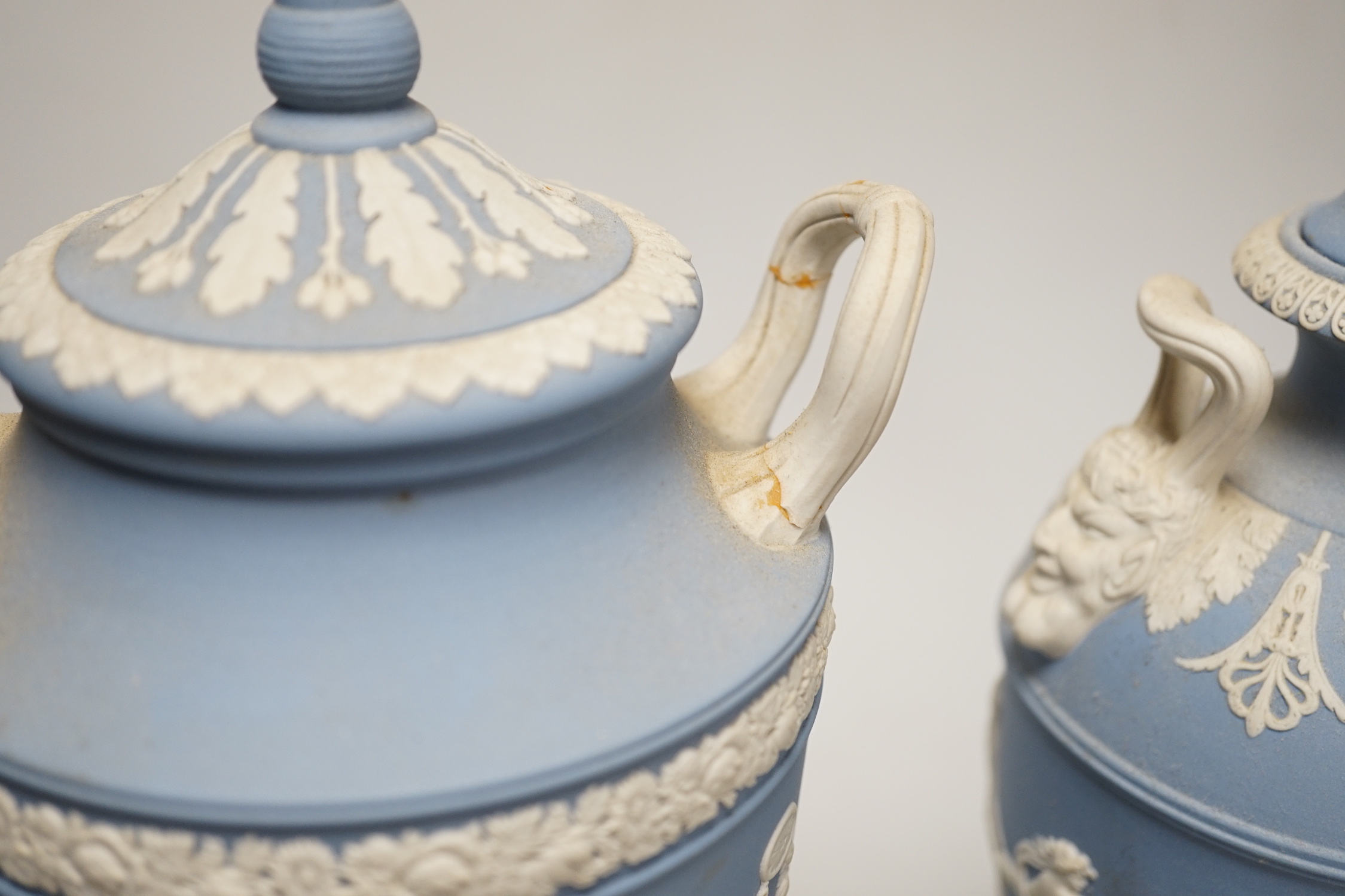A Wedgwood blue jasper commemorative urn and cover and a similar smaller urn and cover, tallest 31cm